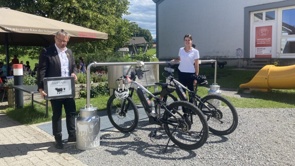 Ralph Böse, Geschäftsführer der «Appenzeller Schaukäserei AG», und Selina Graf, Sales- und Marketingmanagerin, präsentieren die neue E-Bike-Ladestation in Stein. (Bild: pd)