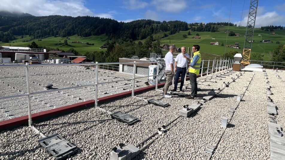 Matthias und Nick Tischhauser (Mitte) lassen sich von SAK-Mitarbeiter Thomas Rechsteiner auf dem Dach des Produktionsgebäudes über den Stand der Arbeiten informieren.(Bild: pd) 