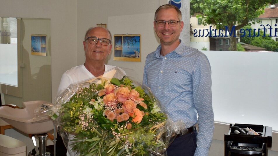 Der Dorf-Coiffeur Markus Rechsteiner (links) empfängt die Gratulationen von Gemeindepräsident Michael Litscher. (Bild: zVg)
