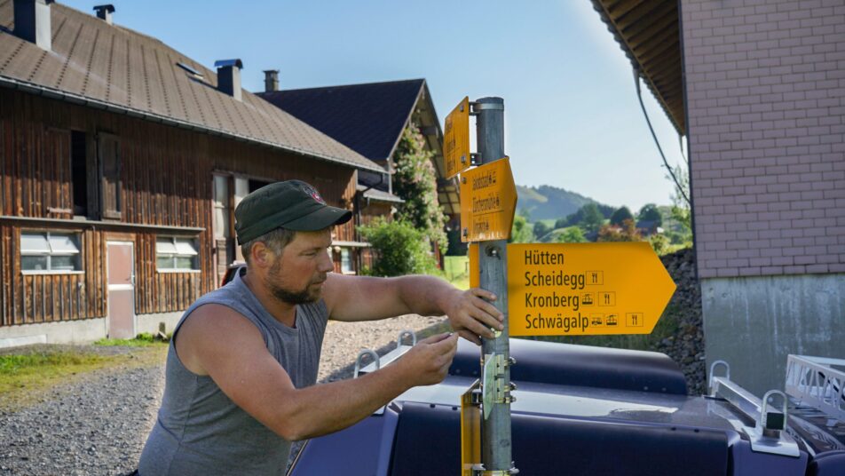 Wegmacher Patric Hautle montiert den Wegweiser Richtung Hütten/Scheidegg bei der Liegenschaft Wees. 24 Stunden später war er bereits wieder entfernt. Der Bezirksrat bittet um Hinweise. (Bild: zVg)